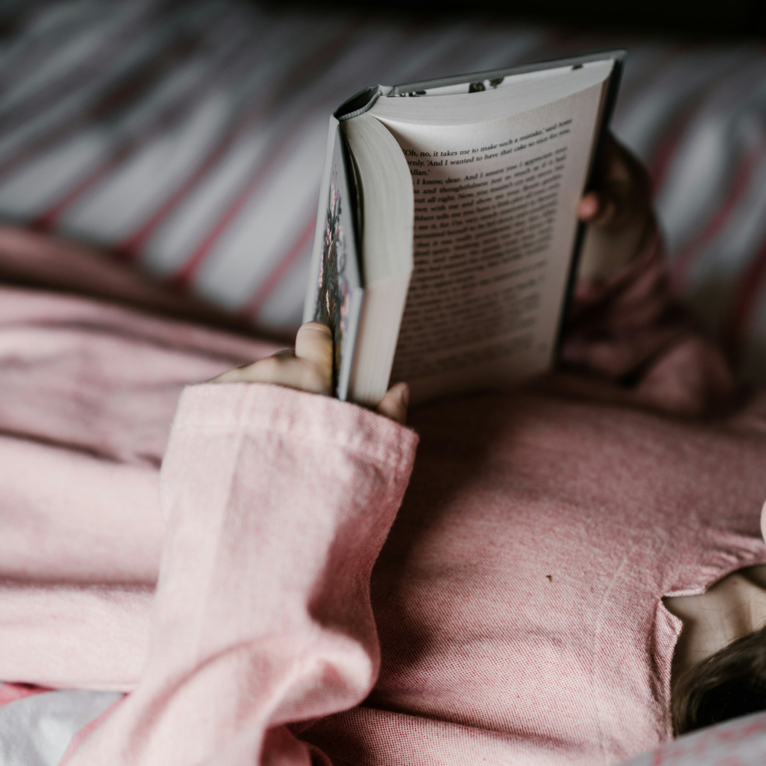 Une enfant en train de lire un livre.