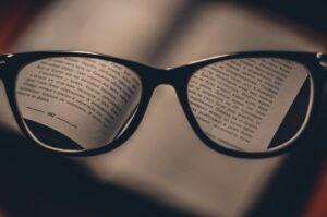 Un livre vu à travers les verres d'une paire de lunettes.