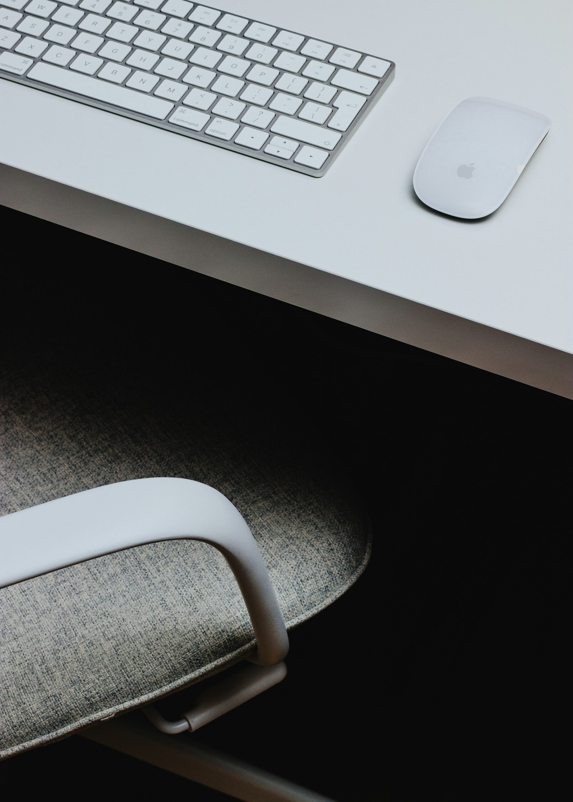 Un bureau épuré, avec une souris d'ordinateur et un clavier.